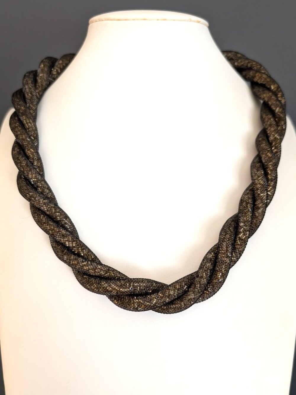 Twisted tubular black netting with gold tone glitter confetti inside necklace